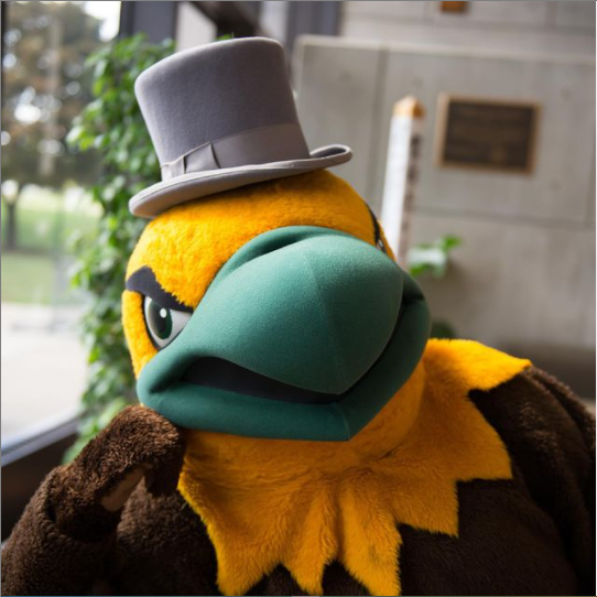 Ellsworth, a golden eagle mascot, leans on his wing (elbow?) wearing a top hat